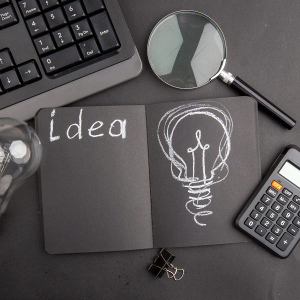 top-view-idea-written-black-notepad-